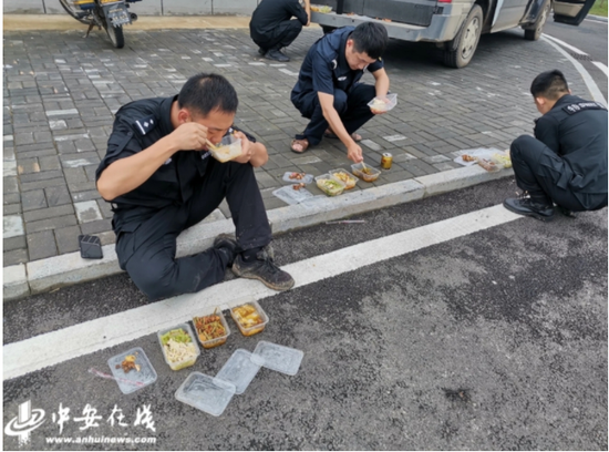 参与抢险转移的公安干警就地吃盒饭