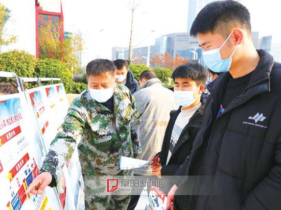 征兵宣传活动现场,适龄青年正在咨询了解相关征兵政策。
