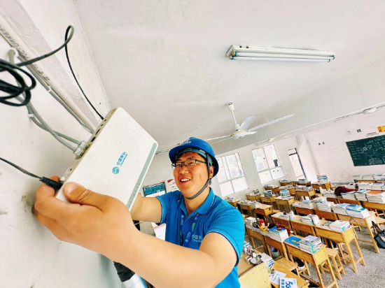 (装维工程师在教室内安装监控)