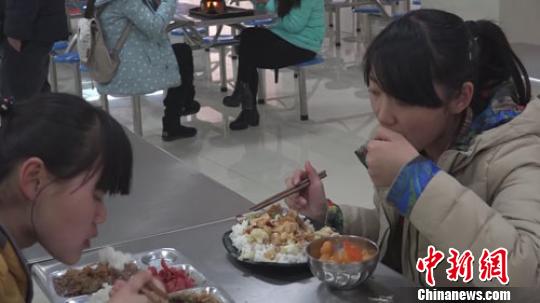 一位女生买了一份胡萝卜炒橘子进行品尝。 阚力 摄