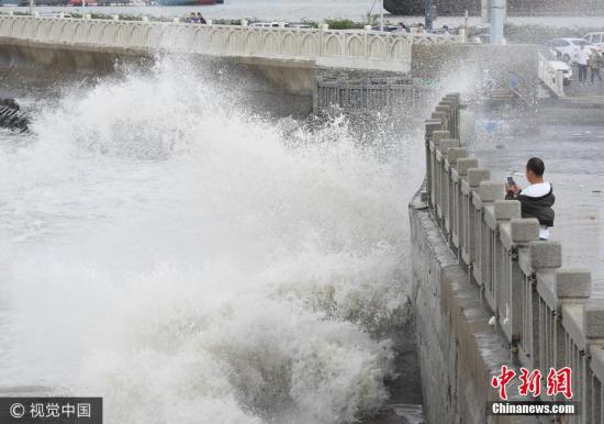 0月2日,游客在连云港市连云区海岸边观赏巨浪。当日,受冷空气影响,江苏连云港沿海出现大风,海滨掀起阵阵巨浪。耿玉和 摄 图片来源:视觉中国