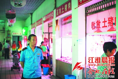 市场监管人员正在巡视菜市场。
