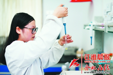 十里店菜市场的工作人员对菜市场经营菜品抽样检验。