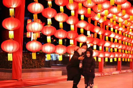 图丨一对母子在合肥火车站广场的红灯笼长廊内拍照留念