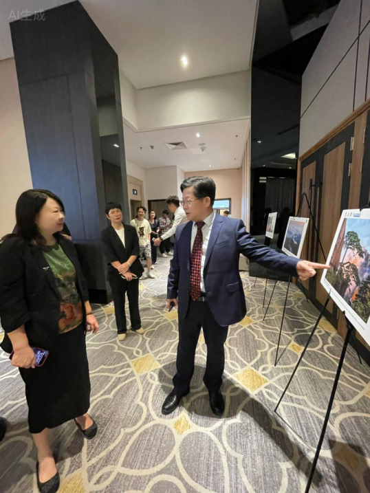 （黄山风景区党工委副书记雷连本向吉隆坡中国文化中心主任韩宁介绍黄山）