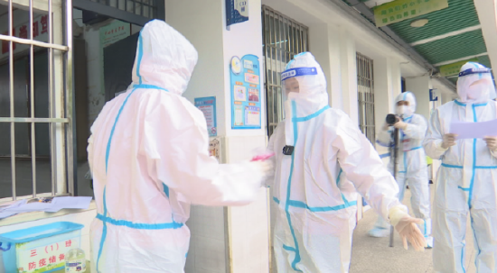 瑶海区大店小学特殊考场外，监考老师正在为考生消毒。（图片来源：合肥新闻频道）