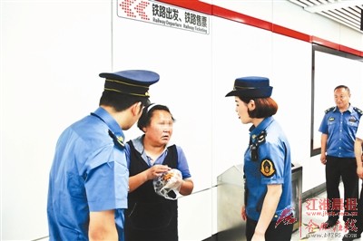 执法人员劝离乞讨人员。