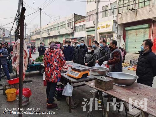 图：执法人员在农贸市场进行检查