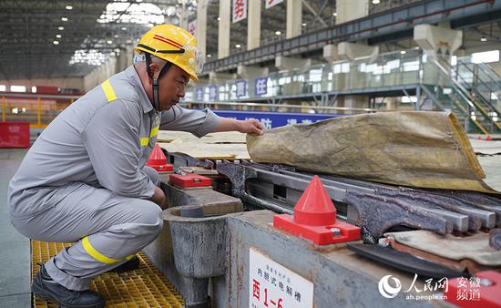 工作人员查看电解槽中的铜板。人民网 王锐摄