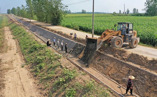  图为安徽农垦华阳河农场的施工人员在浇筑衬砌灌渠，实施旱改水作业。