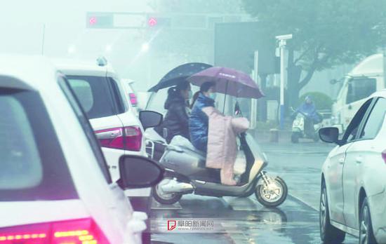 1月25日，雨雾天气给市民出行带来不便，一些车辆在道路上只能减速慢行。记者 王彪 摄