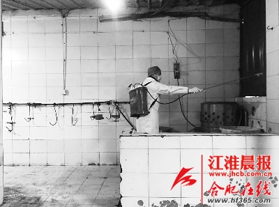 工作人员正对活禽市场进行消毒。