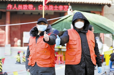 来自天津铁路法院的徐波与刚刚退役的儿子徐天宇父子俩在河北区望海楼金钟里社区核酸筛查点当起志愿者。