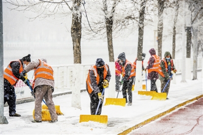 环卫工冒雪清除海河东路人行道上的积雪。