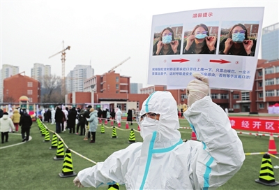 滨海新区志愿者手持核酸检测提示图指导市民