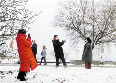 人们纷纷走出户外拍摄雪景。