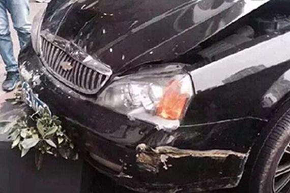 女子误踩油门致车失控 路人被夹车与墙之间