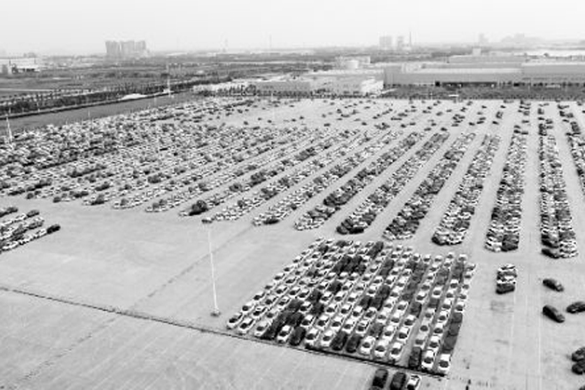 武汉东风本田沌口停车场上，大量待售的汽车折射出我国汽车行业产能过剩的冰山一角。