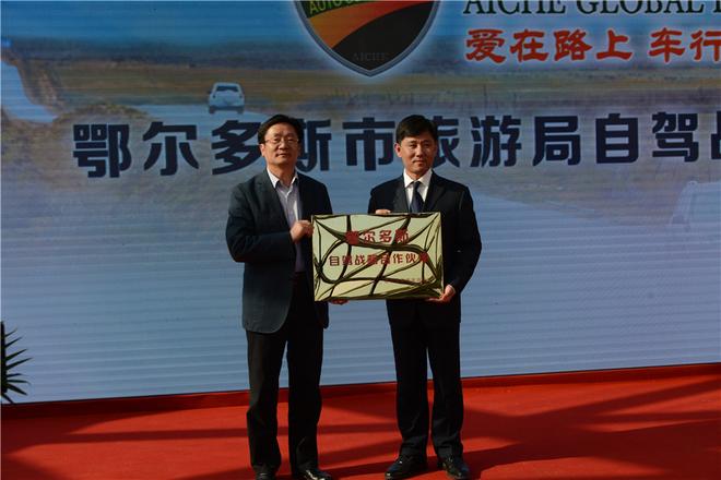 【鄂尔多斯市旅游局自驾战略合作伙伴现场授牌】左一:李国俭副市长;右一:爱车环球自驾汽车文化(集团)俱乐部总会长曹群