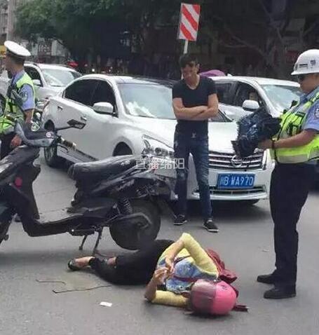 女子出车祸被刮倒 躺地玩手机影响交通