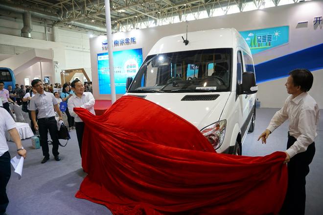 南京金龙副总裁汪先锋（左）及中国公路学会客车分会理事长王奇英（右）为开沃D11纯电动微公交车揭幕