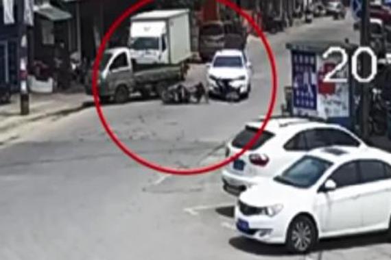 视频：女子遭压车底 众人奋力抬车救人