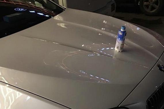 大学门口，在“宝马”车上放瓶饮料……