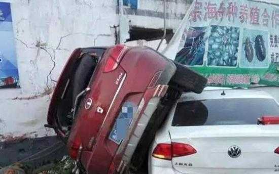 事故现场,红色的“长城”牌小轿车侧翻,压着一辆白色的“大众”牌小轿车。