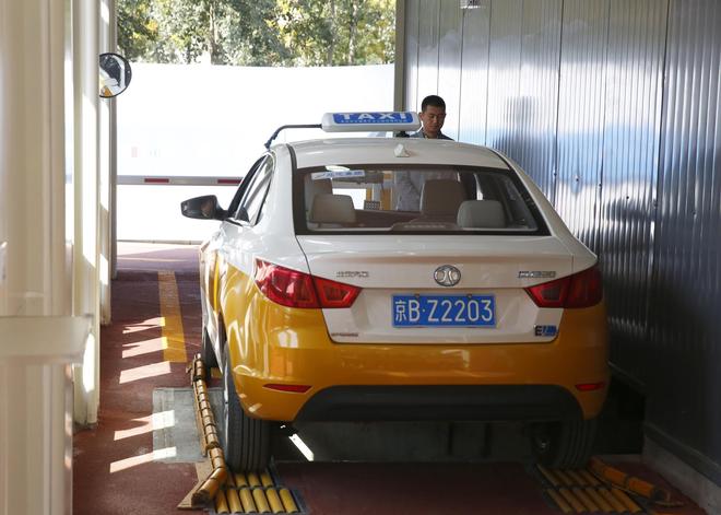 北汽新能源EU220可換電出租車在換電站內(nèi)進(jìn)行換電操作