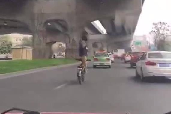 成都一男子站在电动车上打太极