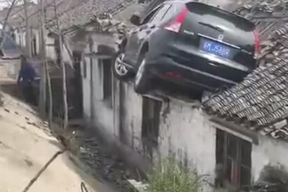 视频：避让三轮车 越野车爬上房