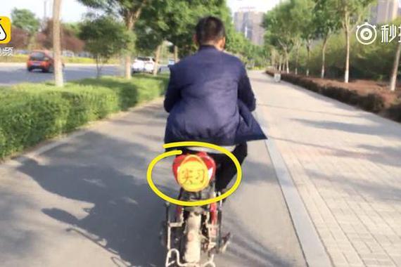 嫌技术不行 男子骑电动车上路挂“实习“
