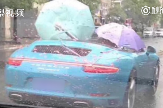 视频：大雨倾盆，男子打雨伞开敞篷