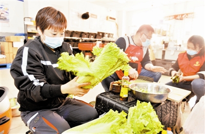 天津顺丰工会的志愿者们来到营业网点为加班加点的职工准备美味可口的饭菜。韩兴芳（左）也帮着志愿者们一起忙活