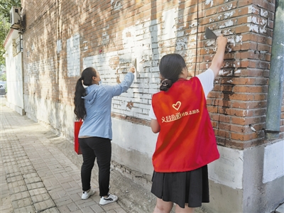 文昌街道社区居民和志愿者参加“百日会战”活动，铲除小区里的小广告