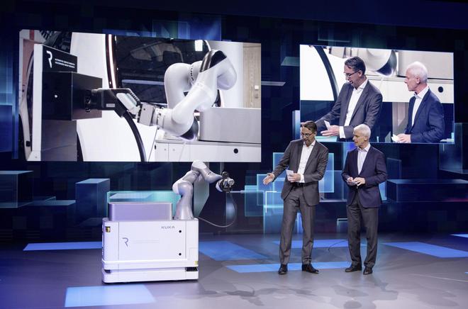 大众汽车集团CEO穆伦(图右)与库卡(Kuka)公司CEO Till Reuter(图左)共同展示了首款可移动的电动汽车充电机器人“CarLa”