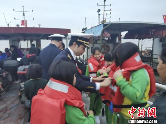 番禺海事处工作人员在渡船上指导学生如何正确穿着救生衣　钟铮　摄