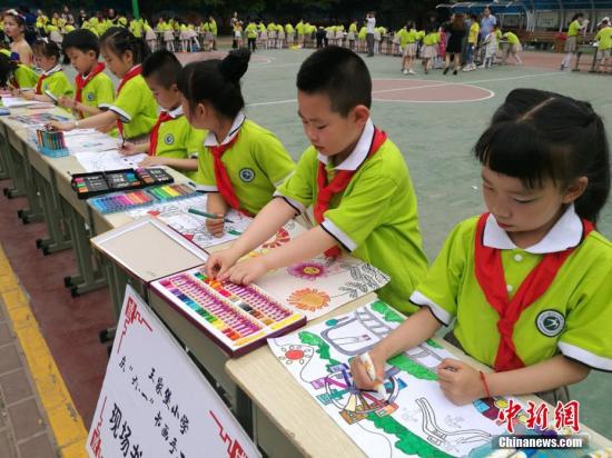 资料图：小朋友展示书法、绘画作品，庆祝儿童节。 达媛 摄