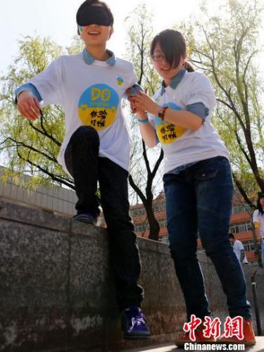 资料图：2014年3月29日，百余名大学生志愿者进行“黑暗体验”。中新社发 富田 摄