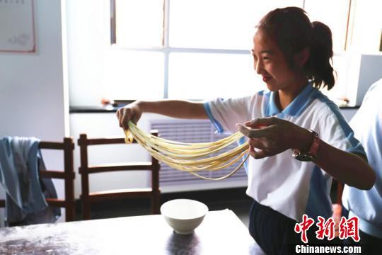 资料图为学生在实践课堂学习拉面。　繆培迪 摄