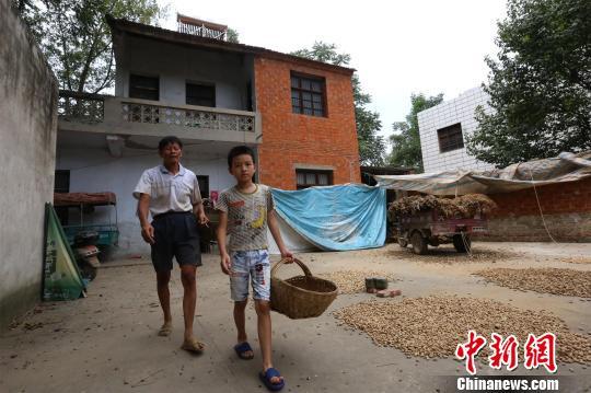 莫钧贤和爷爷莫保先预备去地里挖花生 杨东 摄