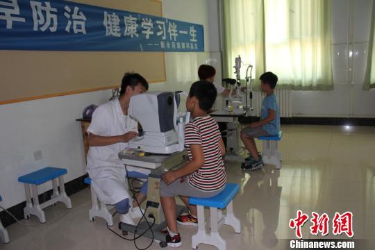 眼科病院的大夫为学生们筛查目力。 王鹏 摄