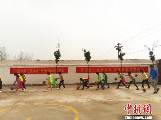 图为孩子们跟随自愿者上篮球课。 韩章云 摄