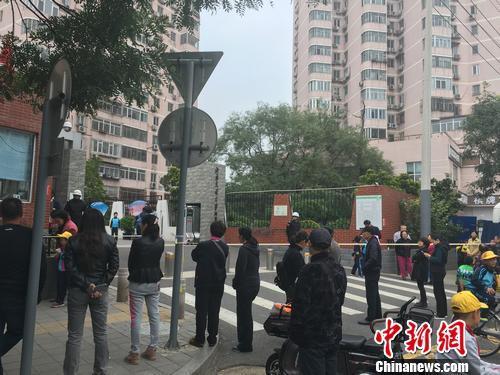资料图:北京西城区一所小学外,不少家长正在等待孩子放学。汤琪 摄