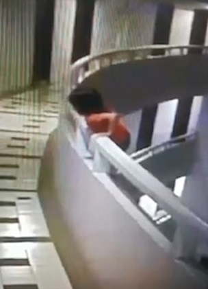 女孩翻越到扶杆外侧。(图源:《每日邮报》)