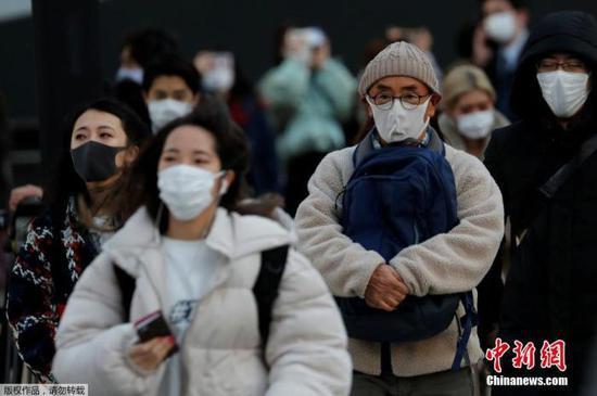 资料图:当地时间1月7日,日本东京,民众佩戴口罩上街。
