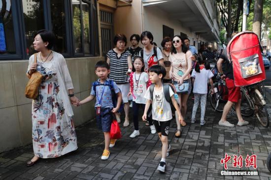 资料图：家长护送孩子们上学。殷立勤 摄