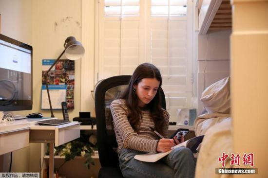 图为美国纽约州一名学生在家中进行线上学习。