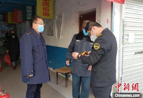 正在检查测温枪是否符合条件的龙斐。　潞州区市场监督管理局供图