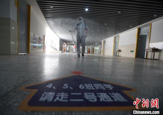 图为消防员正在对人行通道进行全面消杀。 王方 摄
